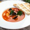 Фото к позиции меню Томатный суп с морепродуктами, имбирем и листьями лайма
