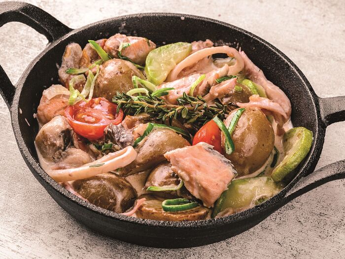 Сковородка с лососем, морепродуктами и овощами в сливочном соусе