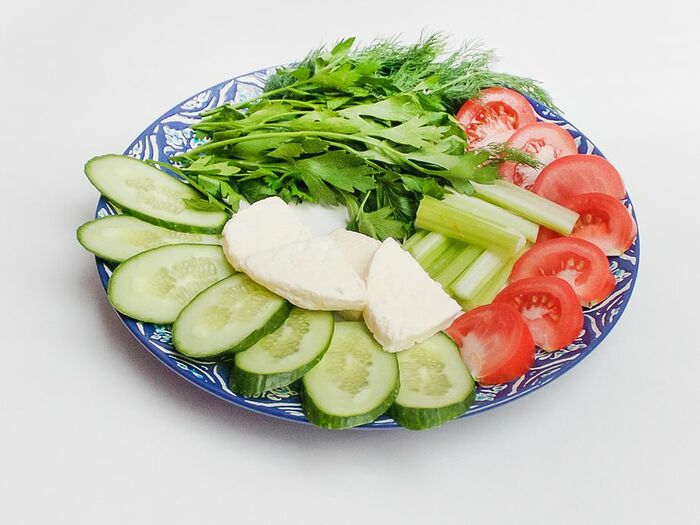 Тарелка овощей, сыра и зелени