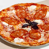 Пицца Калабрезе с итальянской колбаской, жареным луком и сливочным сыром
