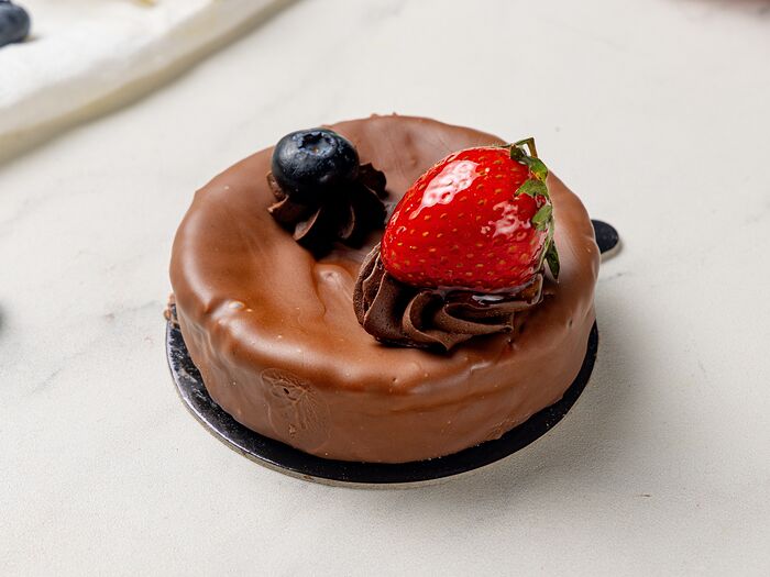 Пирожное чизкейк Нью-Йорк с шоколадом, ягодами клубники и голубики