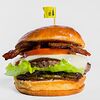 Фото к позиции меню Фирменный чизбургер с беконом, карамелизированным луком и маринованными огурцами