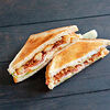 Фото к позиции меню Сэндвич с курицей, луковыми кольцами и ореховым соусом