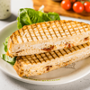 Фото к позиции меню Горячий сэндвич с индейкой, сыром Моцарелла и домашней заправкой цезарь