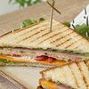 Фото к позиции меню Фирменный сэндвич с ветчиной и беконом (два треугольничка)