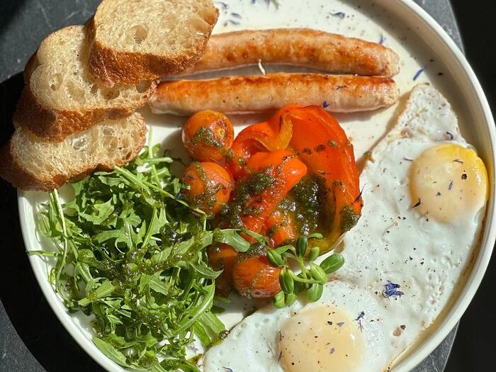 Глазунья с колбасками, овощами и соусом песто