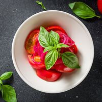 Спелые томаты с красным луком и базиликом
