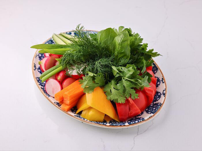 Тарелка с зеленью и свежими овощами