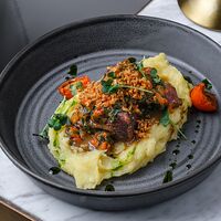 Разварные щечки в мясном соусе с печеным перцем и картофельным пюре