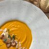 Фото к позиции меню Фирменный морковно-сливочный суп с тигровыми креветками