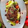 Фото к позиции меню Тальята из говядины на листьях салата с соусом из красного вина