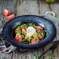 Свежий овощной салат с киноа, авокадо и яйцом пашот