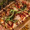 Фото к позиции меню Пицца с копченостями и беконовыми чипсами