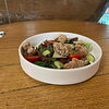 Фото к позиции меню Теплый салат с куриным бедром, свежими овощами и пармезаном