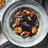 Фото к позиции меню Черные спагетти с морепродуктами в соусе том ям