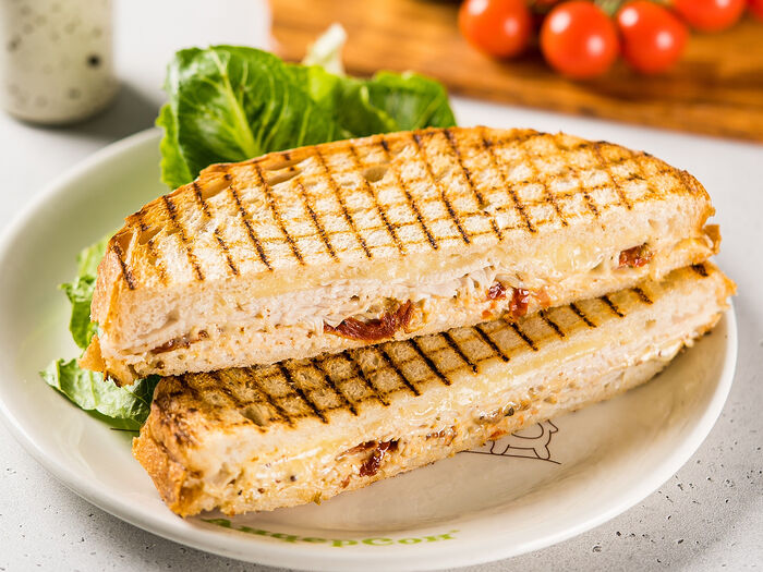Сэндвич с индейкой, тянущимся сыром моцарелла, вялеными томатами и домашней заправкой цезарь
